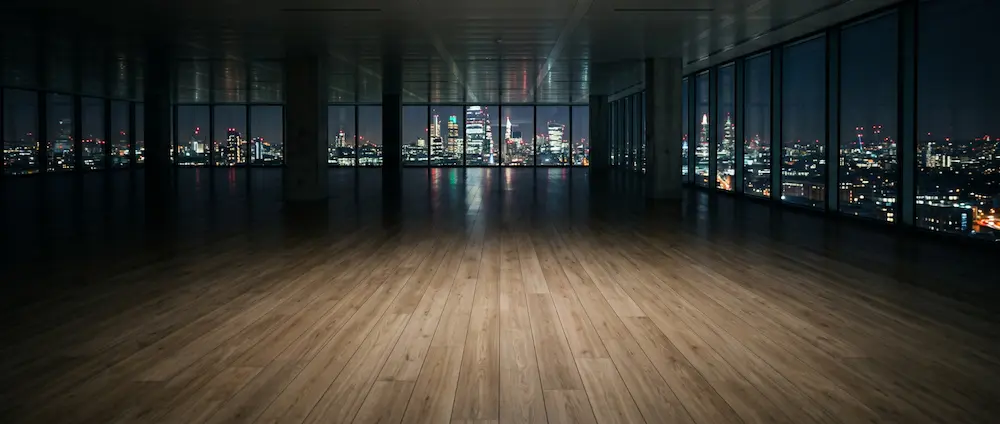 light oak laminate flooring in large empty commercial office space at night